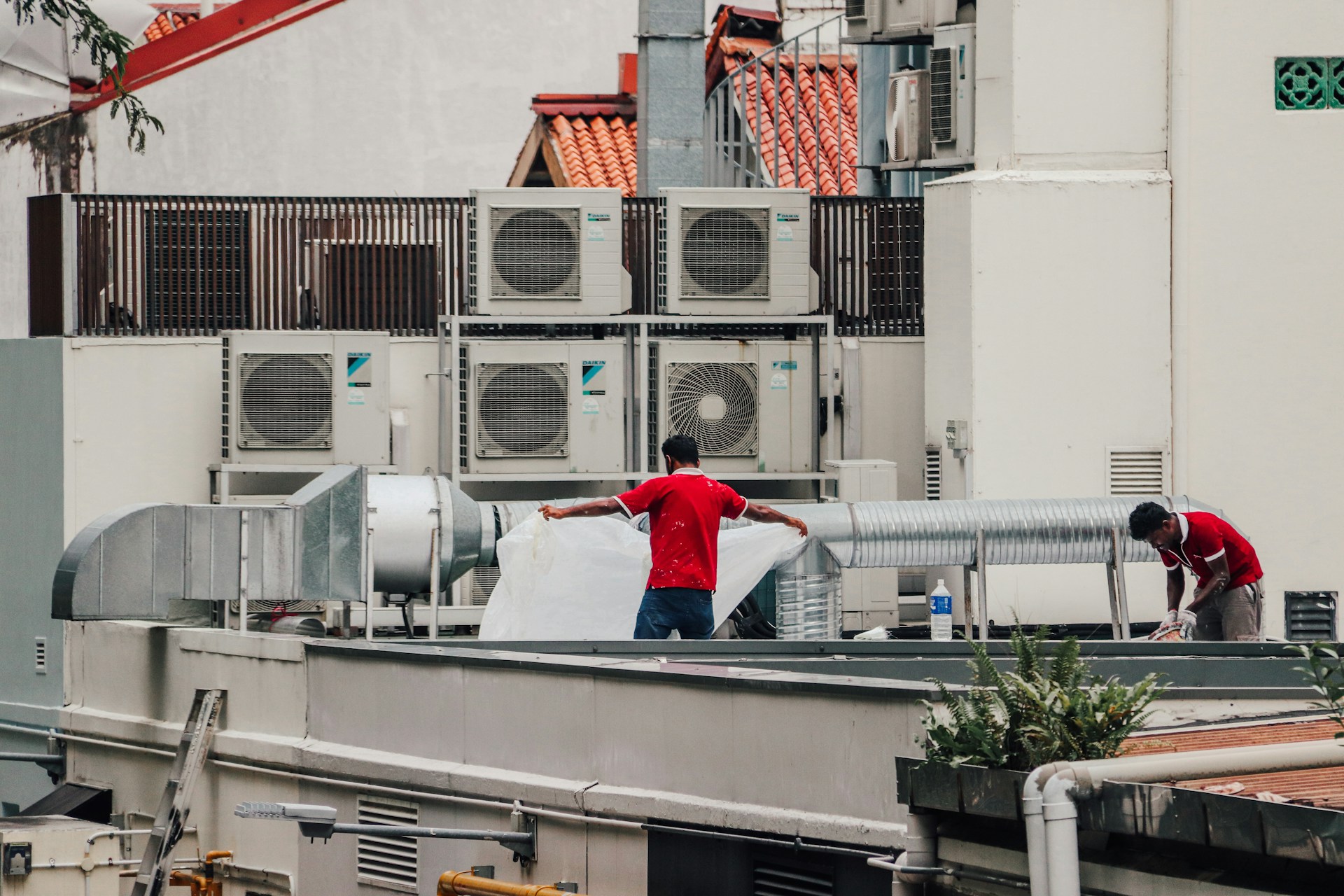Técnicos instalando sistemas de aire acondicionado en azotea